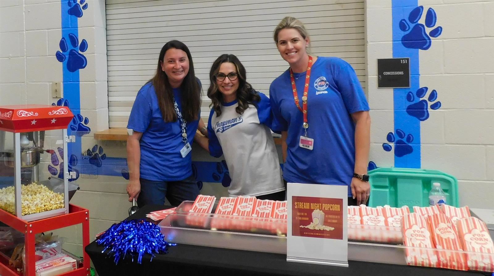 three women behind a popcorn stand